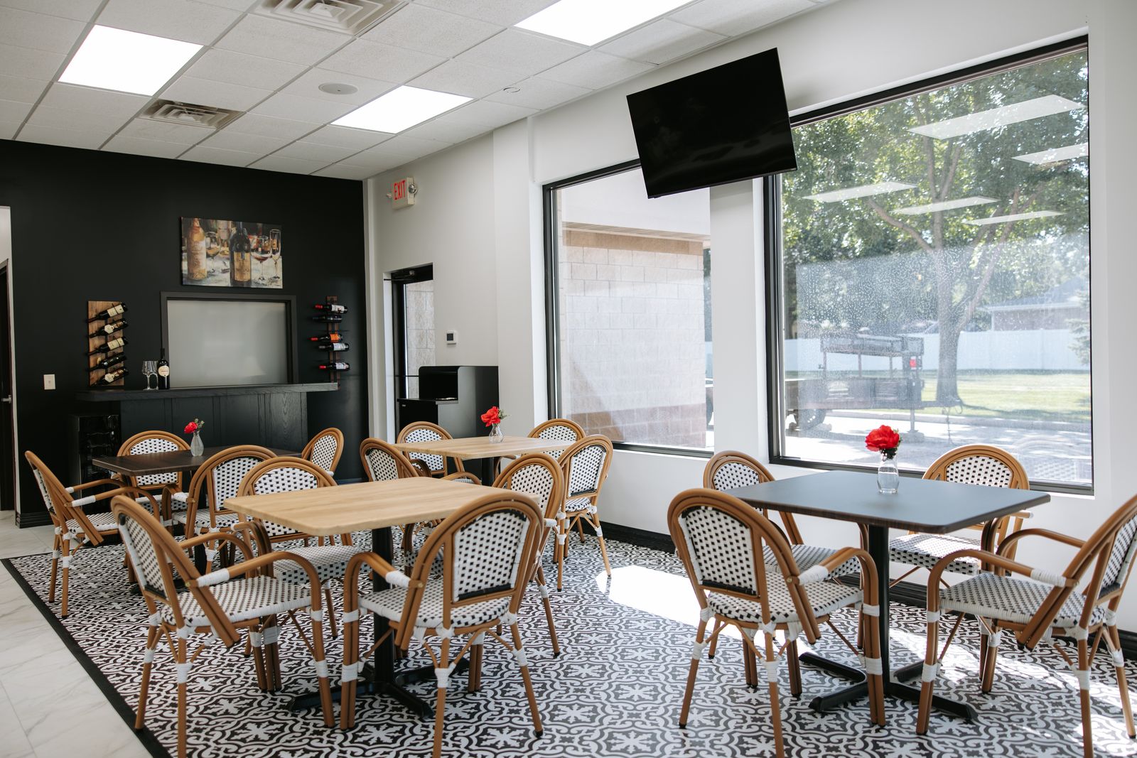 The Modern Meze dining room with rattan bistro chairs, patterned tile, and big front windows