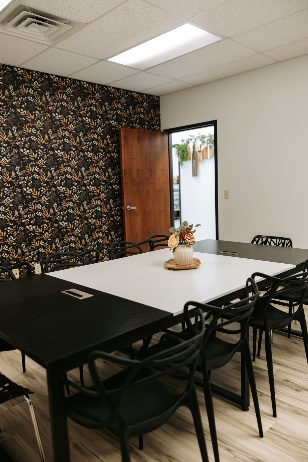 The meeting room with a botanical accent wall and seating for ten