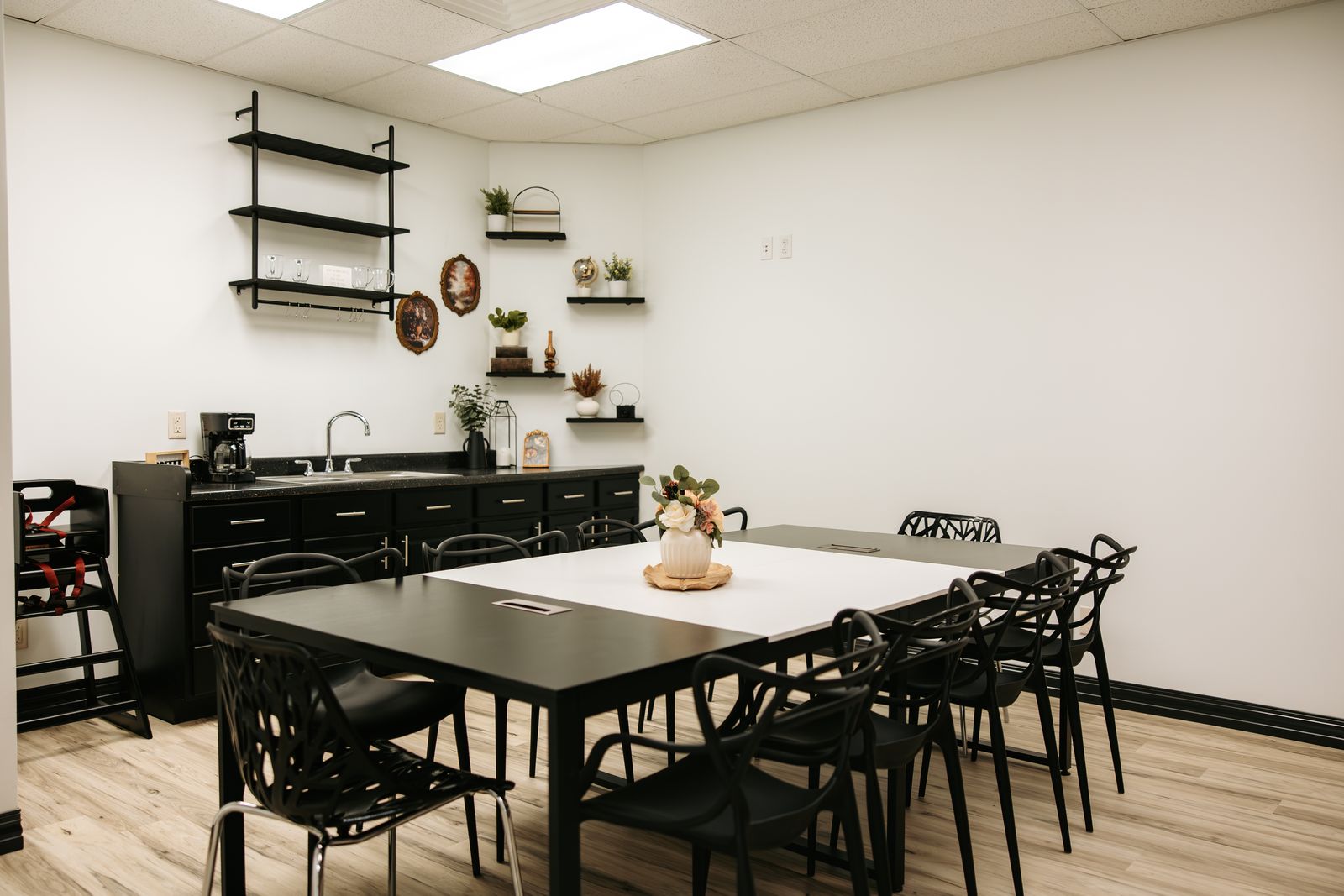The private event room set with a long table, black chairs, and a coffee bar